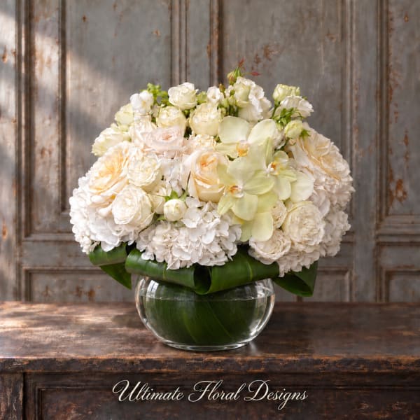 Creamy white floral arrangement in a clear glass bowl vase
