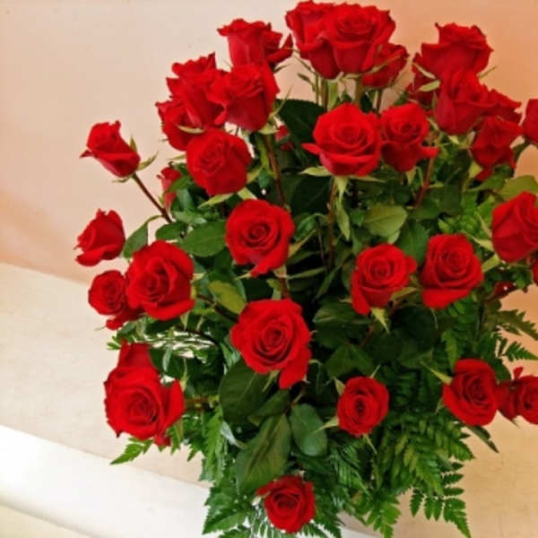 Tall bouquet of red roses with greenery