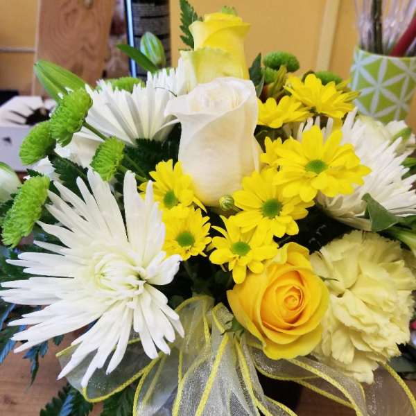 Yellow and white bouquet with roses, daisies, and a ribbon bow