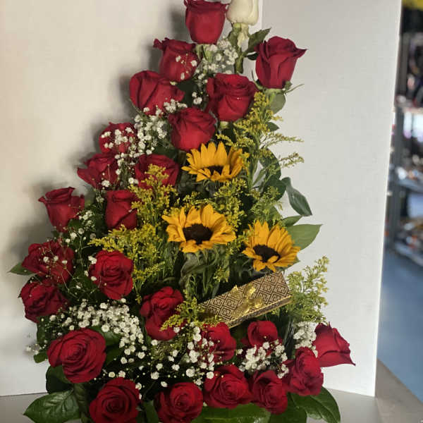Basket arrangement of red roses with yellow sunflowers, baby's breath, and a gold ribbon
