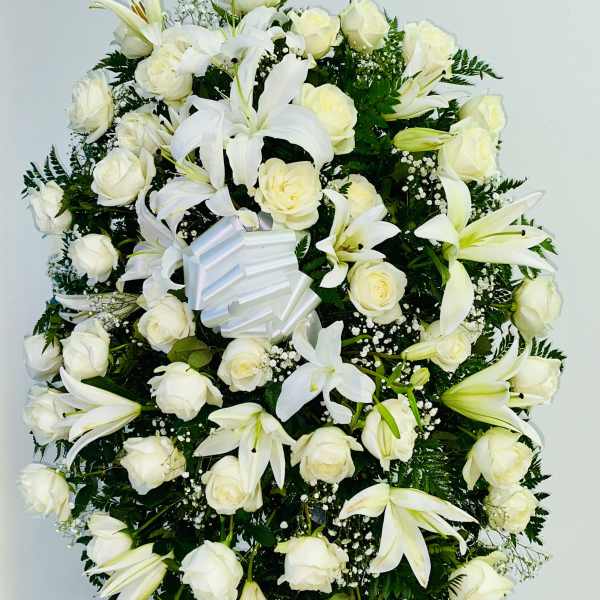 White rose and lily standing spray with a ribbon bow