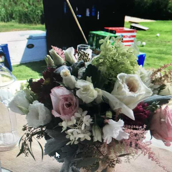 Mixed floral centerpiece with pink and white blooms in a low container