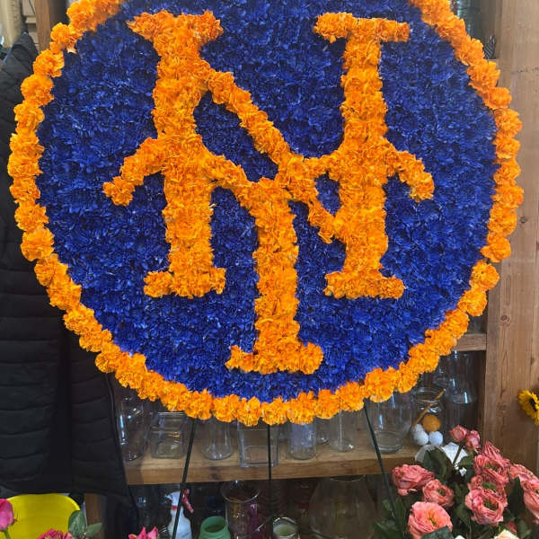 Round floral sign with orange letters on a blue flower background