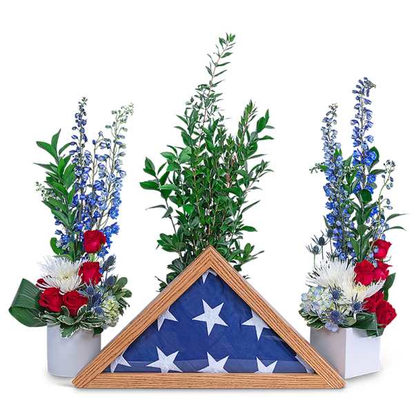 Red, white, and blue floral tribute with a folded flag in a wooden frame