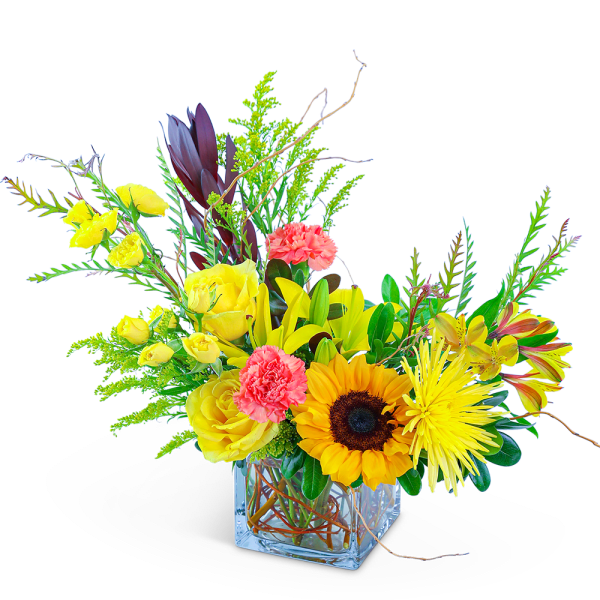 Bright mixed bouquet in a clear square vase with sunflowers and yellow roses