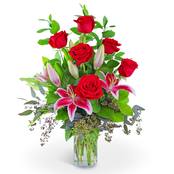 Red roses and pink lilies in a clear glass vase