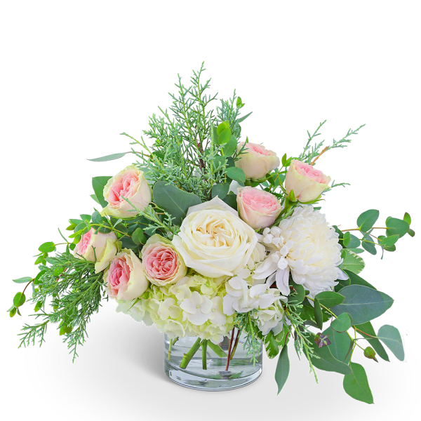 Bouquet of blush and white roses in a clear glass vase