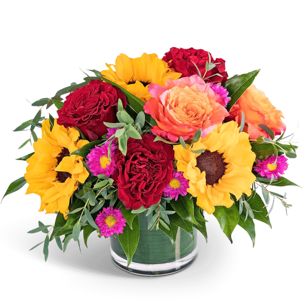 Mixed bouquet of red roses, sunflowers, and pink daisies in a glass vase
