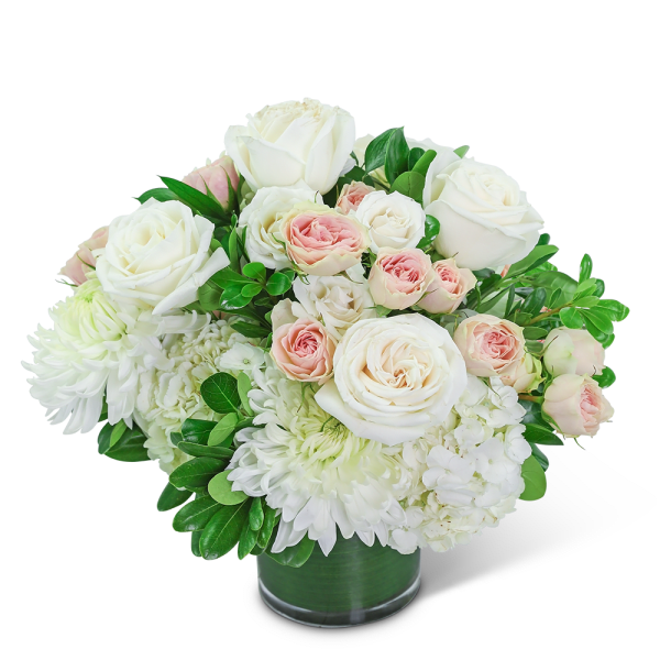 White and blush roses arranged in a glass vase