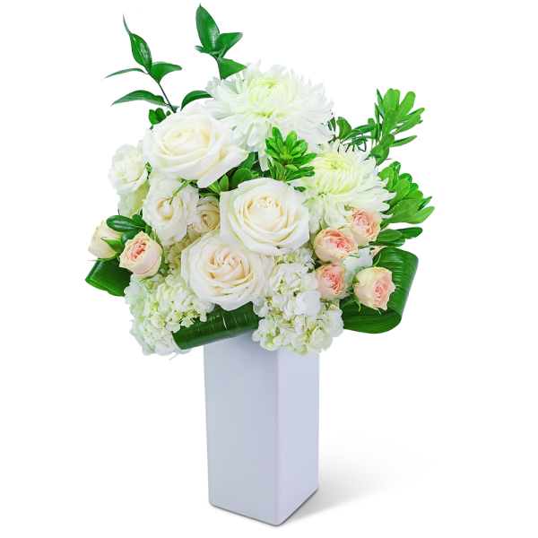 White roses and chrysanthemums in a tall white vase
