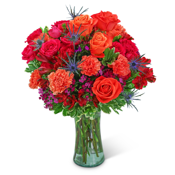 Bouquet of orange and red roses with carnations in a glass vase