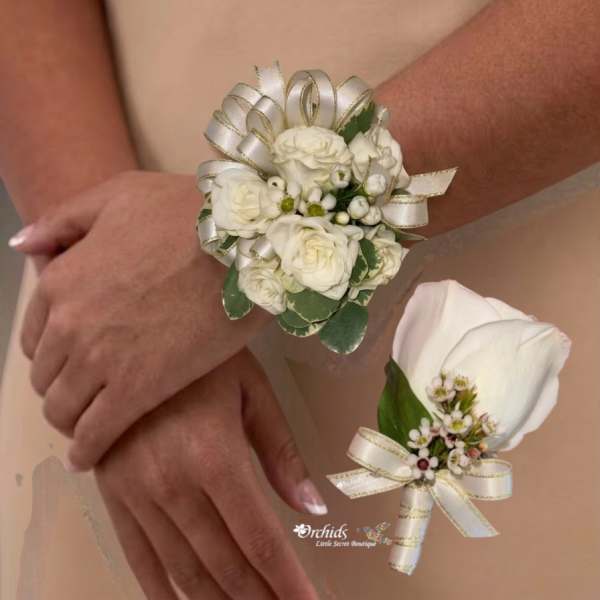 Two white floral wrist corsages worn on arms, each tied with ribbon.