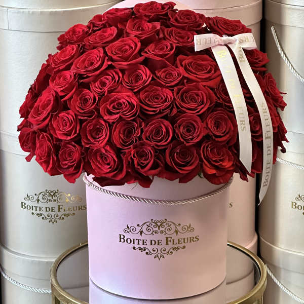 Round box of red roses with a ribbon bow