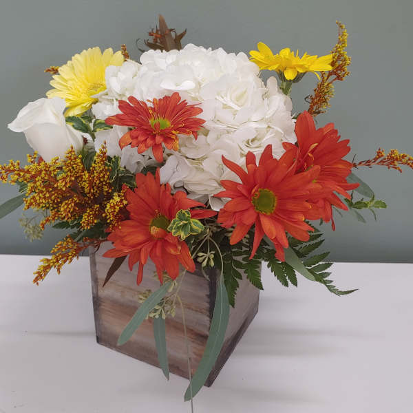 Mixed bouquet in a wooden box with white, red, and yellow flowers