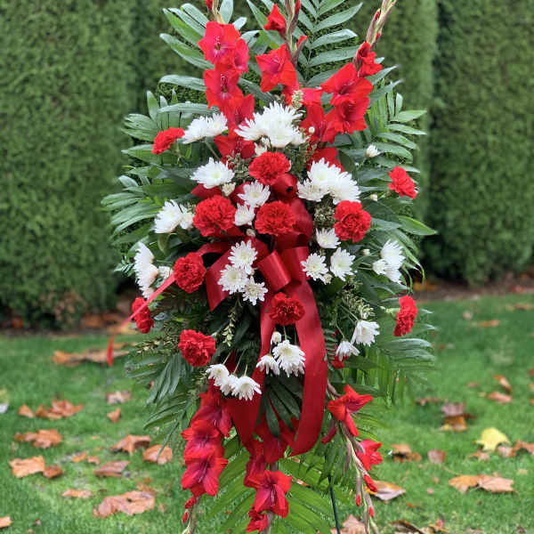 Standing red and white floral spray with ribbon on a wire easel