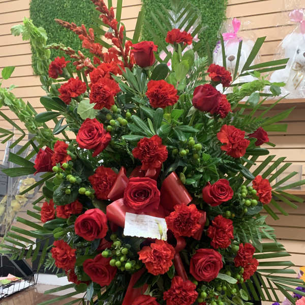Large red rose and carnation standing spray with ribbon