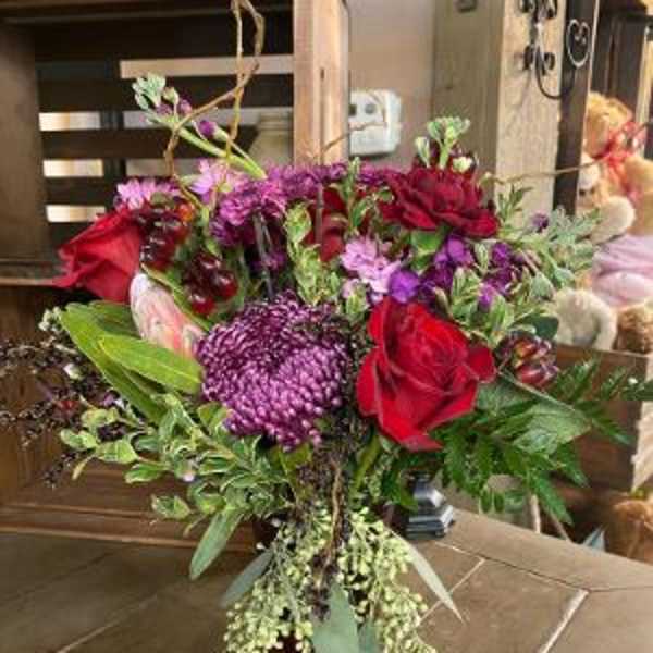 Bouquet of red and purple flowers in a dark vase