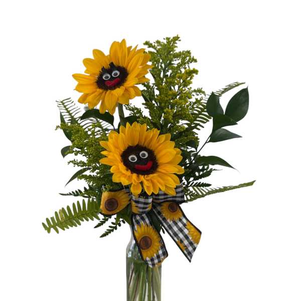 Tall sunflower arrangement with smiling faces in a clear glass bottle with a checked sunflower bow.
