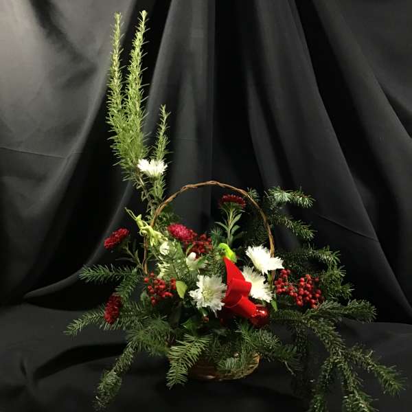 Basket arrangement with white and red flowers and evergreen branches