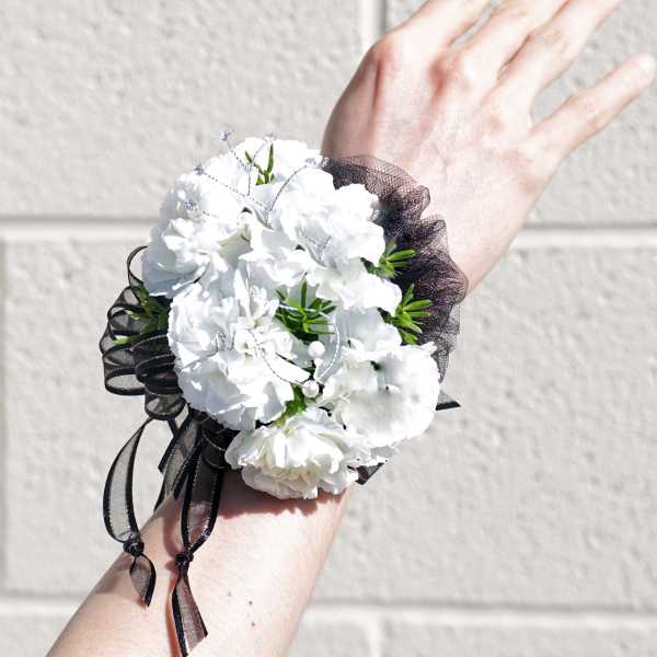 White carnation wrist corsage with black ribbon