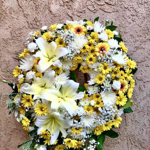 Yellow and white floral wreath on a stand