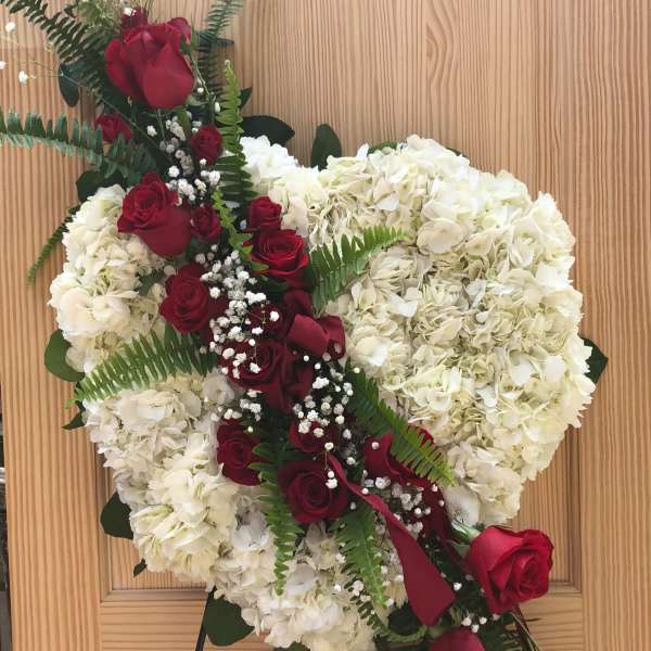 Heart-shaped floral wreath with red roses and white hydrangeas