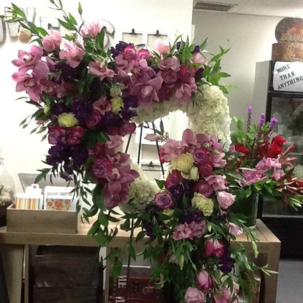 Large floral heart arrangement with pink, purple, and white flowers