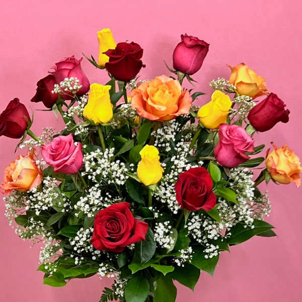 Mixed roses in a clear glass vase with baby's breath