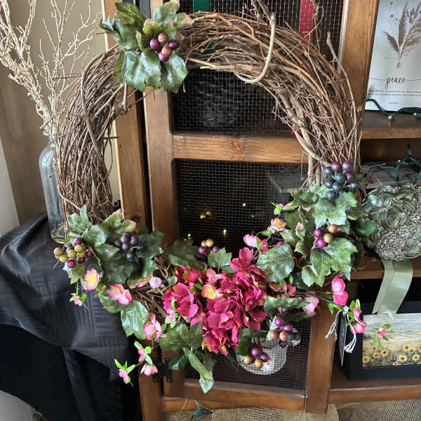 Decorative grapevine wreath with pink flowers and berry clusters