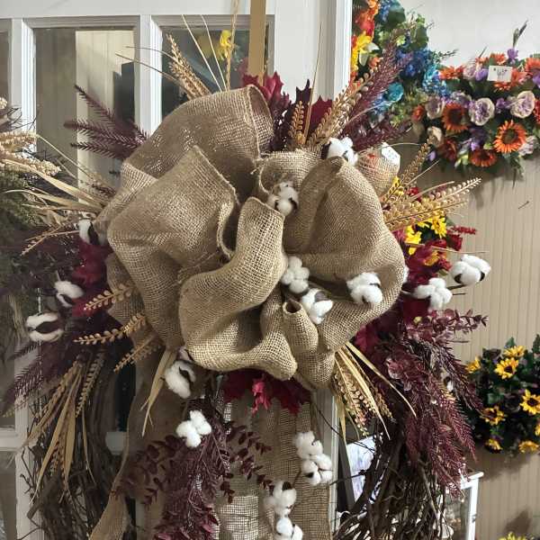 Rustic wreath with burlap bow, cotton bolls, and burgundy foliage