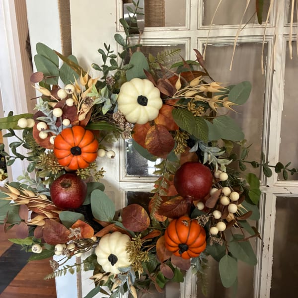 Autumn wreath with pumpkins, apples, berries, and mixed foliage