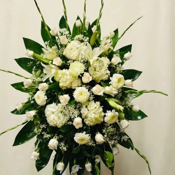 Large white floral spray with hydrangeas, roses, and lilies