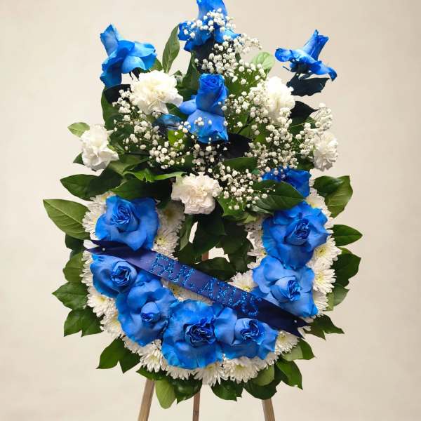 Blue and white floral wreath on an easel with a ribbon