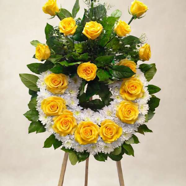 Yellow roses arranged in a wreath on a wooden easel