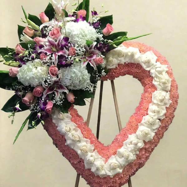 Heart-shaped floral wreath with pink and white flowers and a mixed bouquet on the left