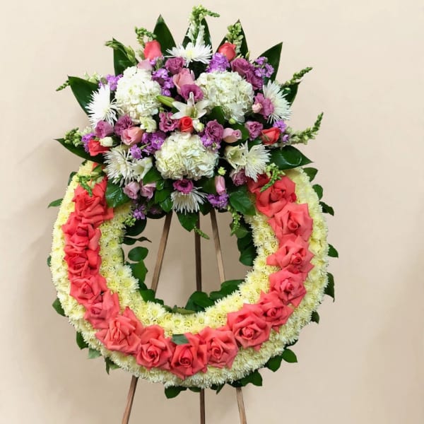 Large floral wreath on an easel with pink roses and white flowers