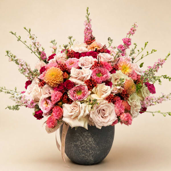 Pink and cream rose bouquet in a dark vase