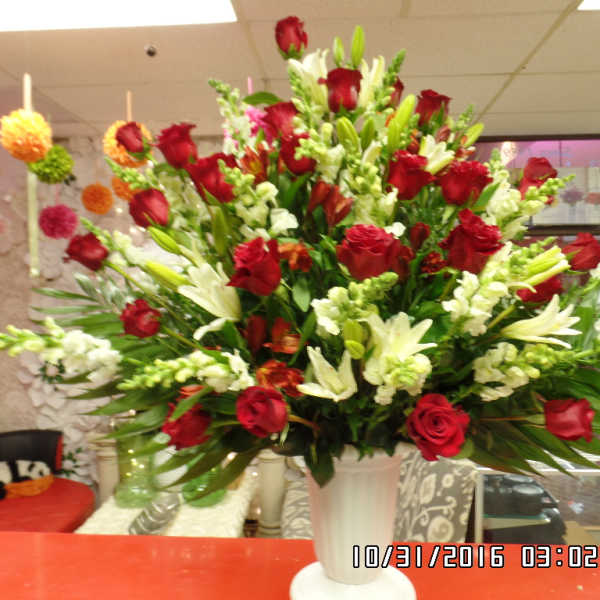 Large bouquet of red roses and white lilies in a white vase