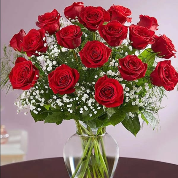 Bouquet of red roses with baby's breath in a clear glass vase