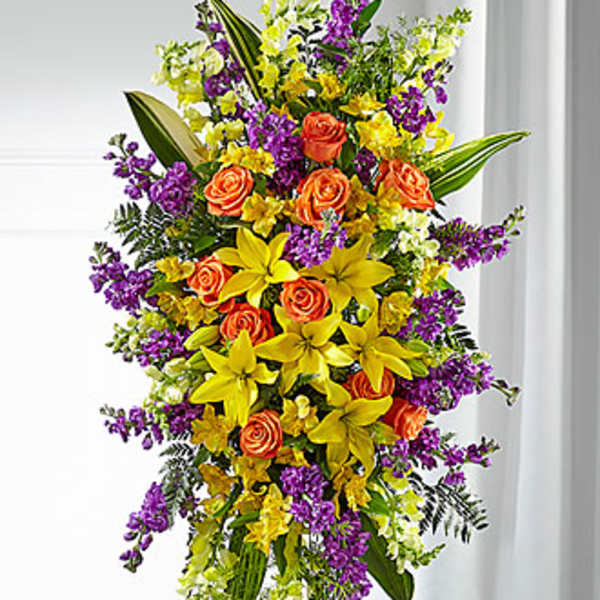 Tall floral spray with orange roses, yellow lilies, and purple flowers