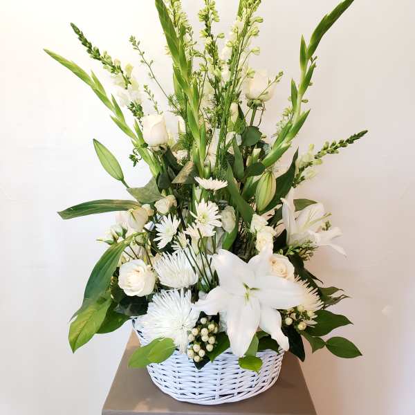 White floral arrangement in a white wicker basket