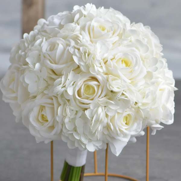 Round bridal bouquet of white roses and hydrangeas with wrapped stems