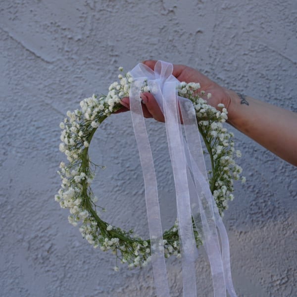 White baby's breath floral wreath with a sheer ribbon bow