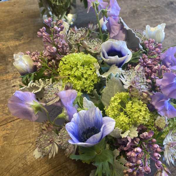 Bouquet of purple and white flowers with bright green accents