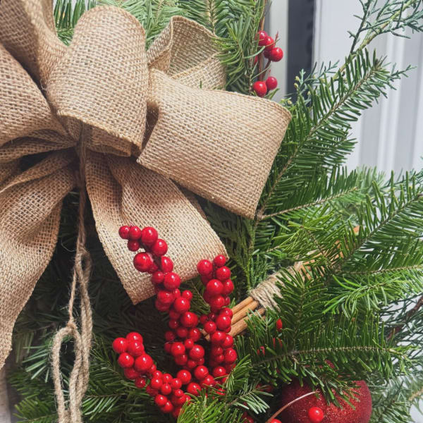 Holiday wreath with burlap bow and red berries