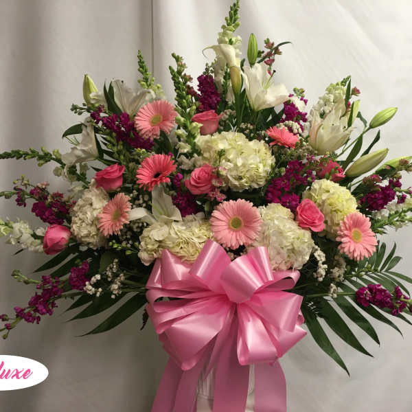 Pink and white mixed flower arrangement with a large pink bow
