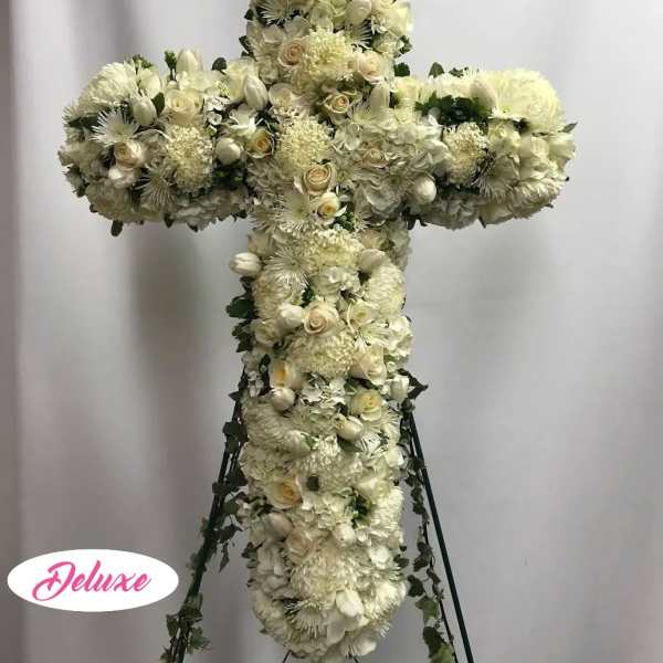White floral cross arrangement on a stand