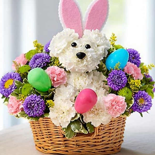 Basket arrangement with a plush bunny and pastel flowers, plus colorful eggs