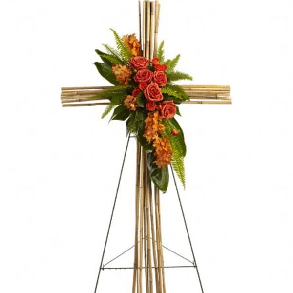 Floral cross on an easel with red roses and orange flowers