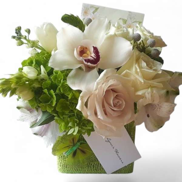 Bouquet of white orchids, roses, and green flowers in a square container